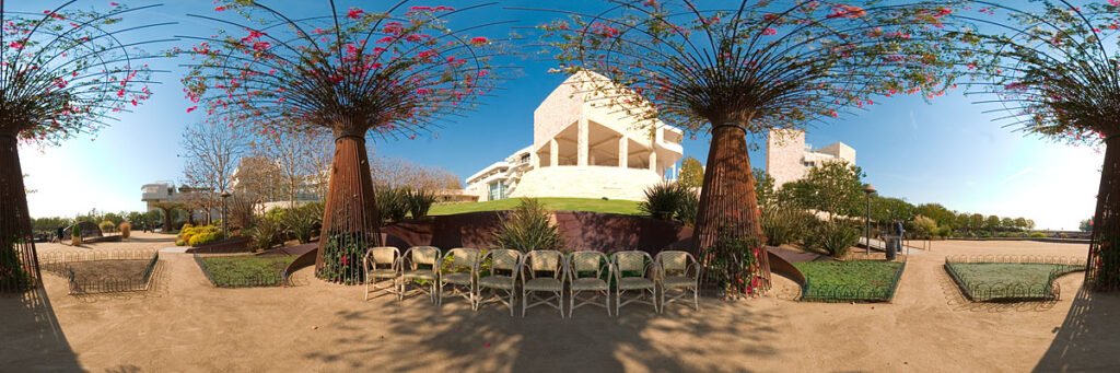 A rest area sits among these giant rebar planters spilling over with flower vines.